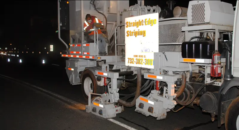 Worker operating striping equipment