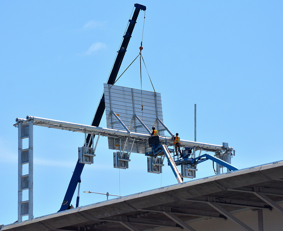 Workers installing a highway sign