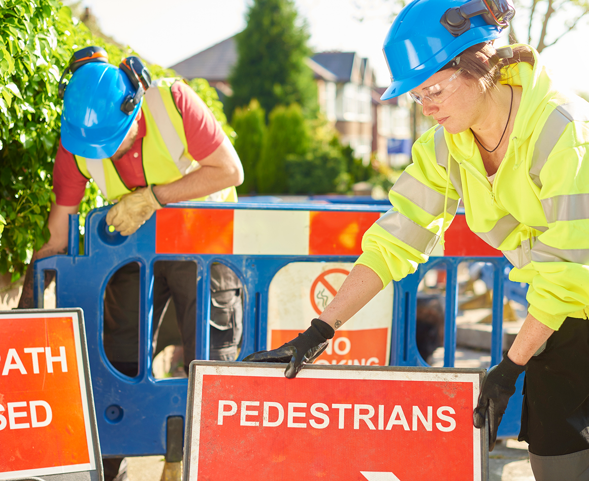Construction workers setting up pedestrian signs