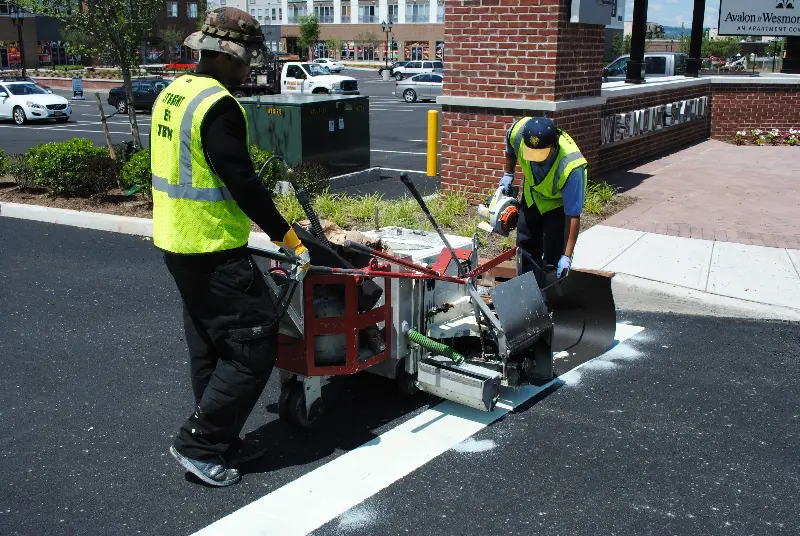 Workers painting parking lot lines