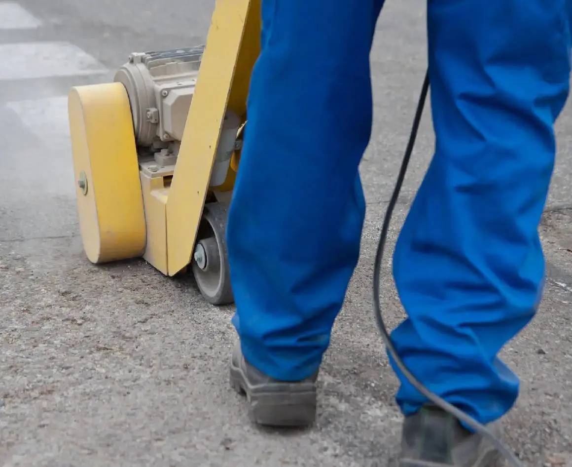 Worker in blue pants removing paints
